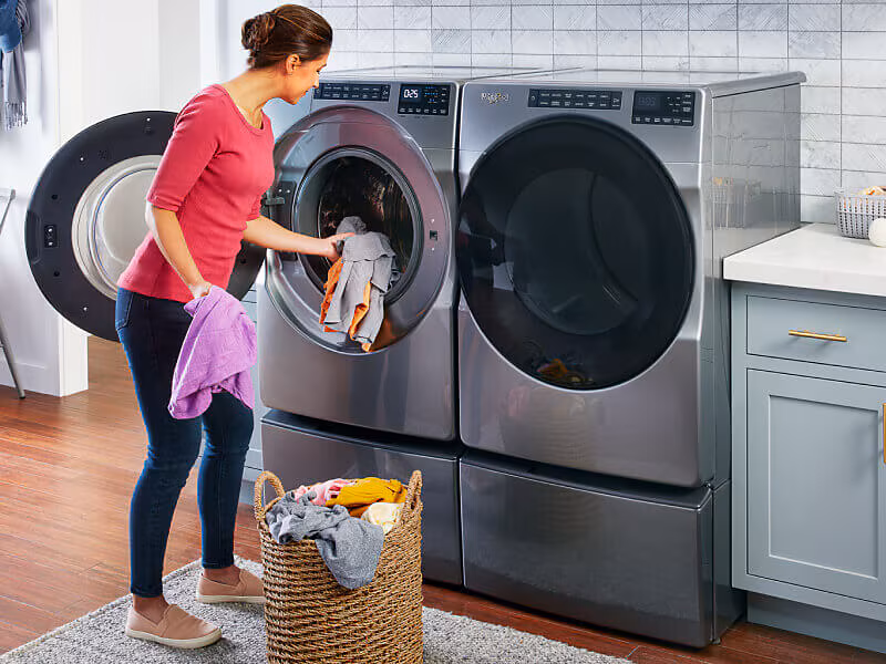 Woman using a high-capacity washing machine at a laundromat in Frederick MD for large laundry loads and bedding