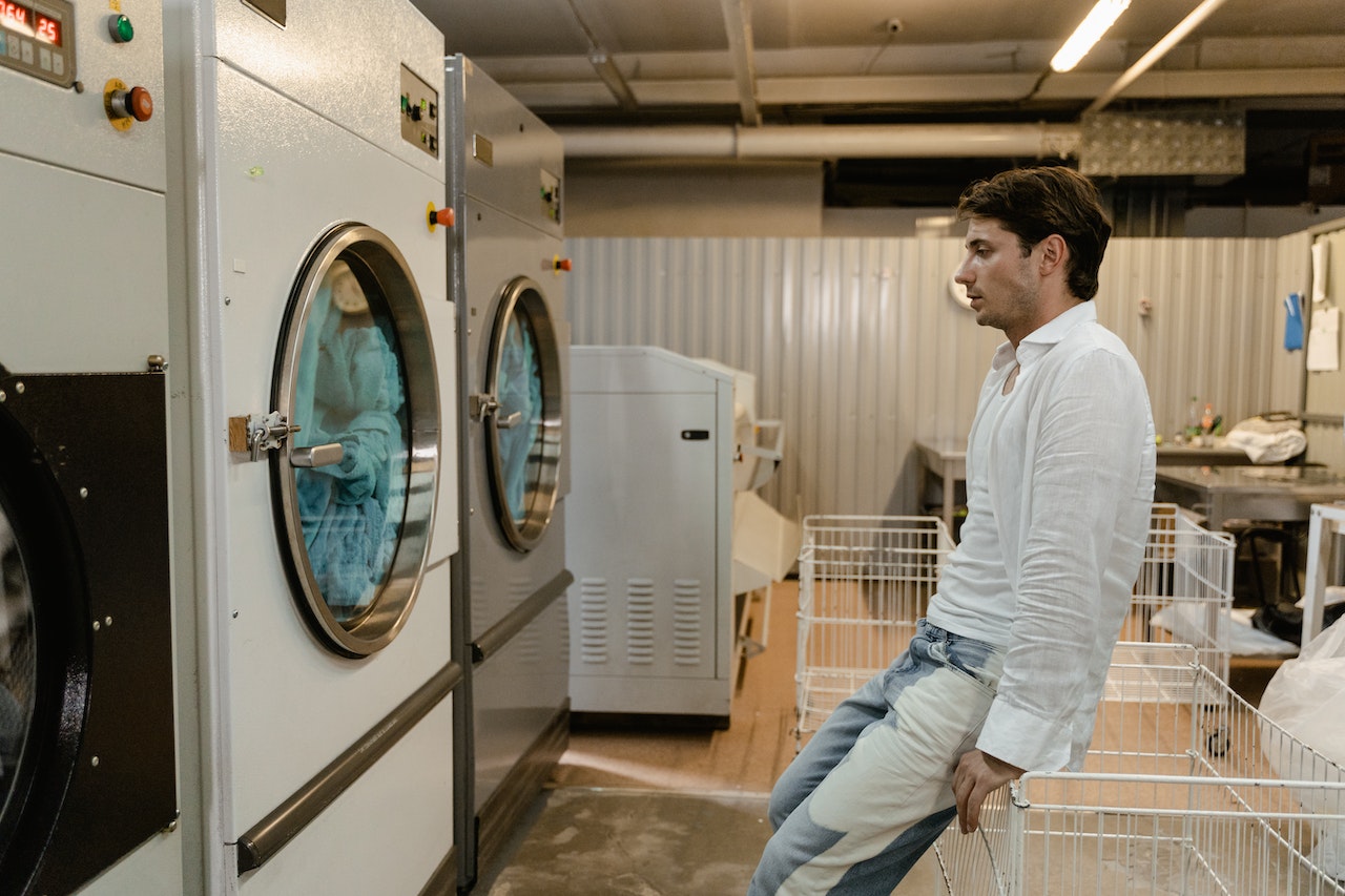 Customer using self-service laundry facilities with commercial washers and dryers near Ballenger Creek MD