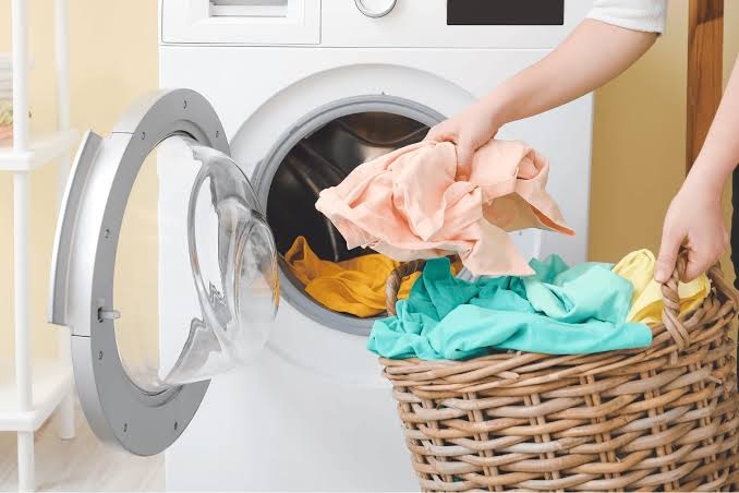 Woman organizing laundry before washing to protect delicate clothing and improve laundry results in Frederick MD
