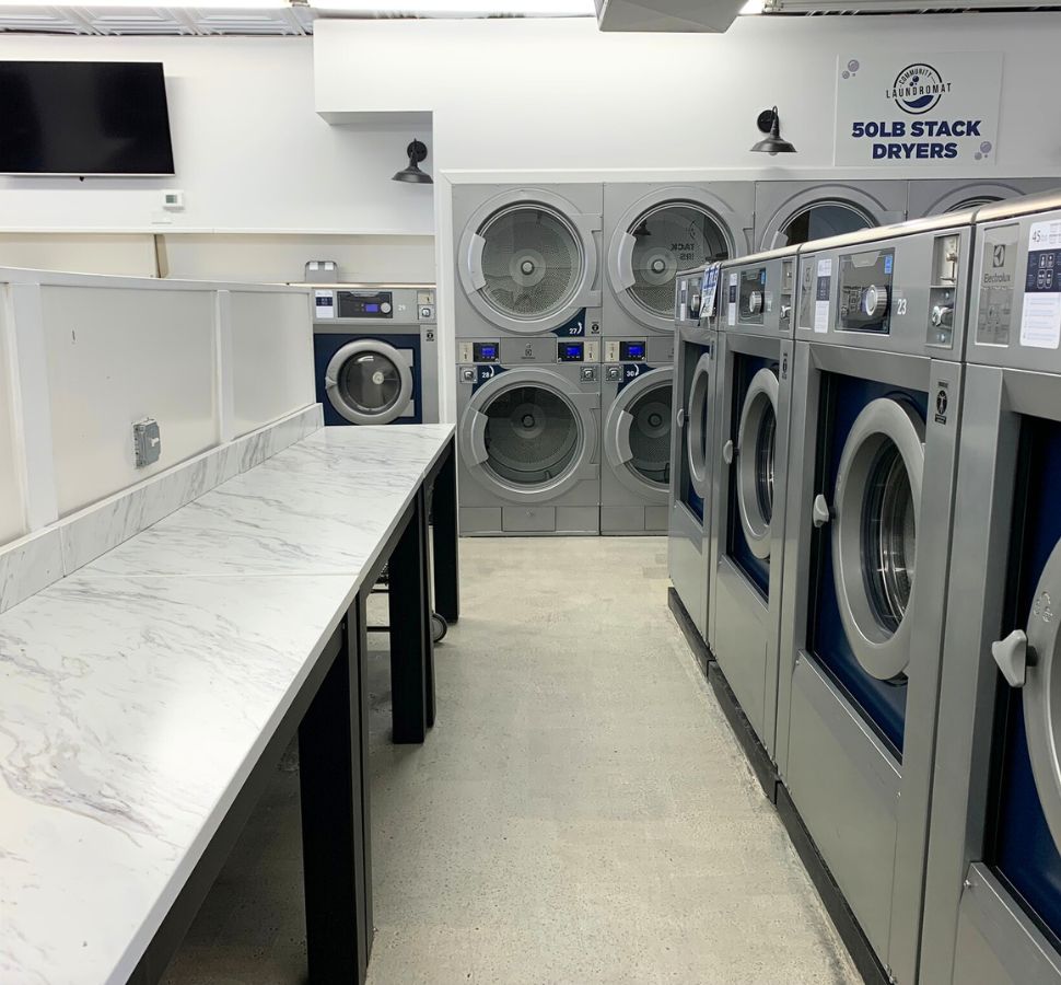 Commercial laundry room with multiple washing machines and folding countertop