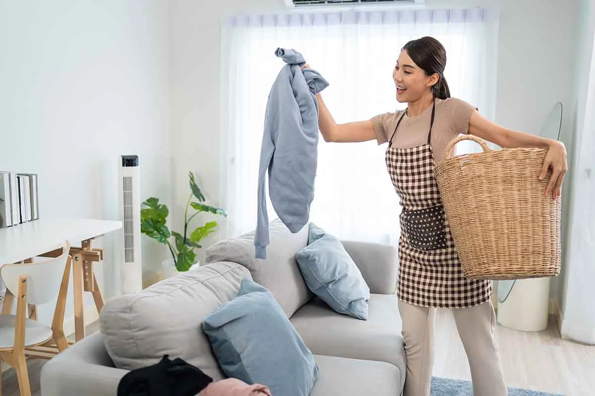 Airbnb host holding a basket of freshly laundered clothes