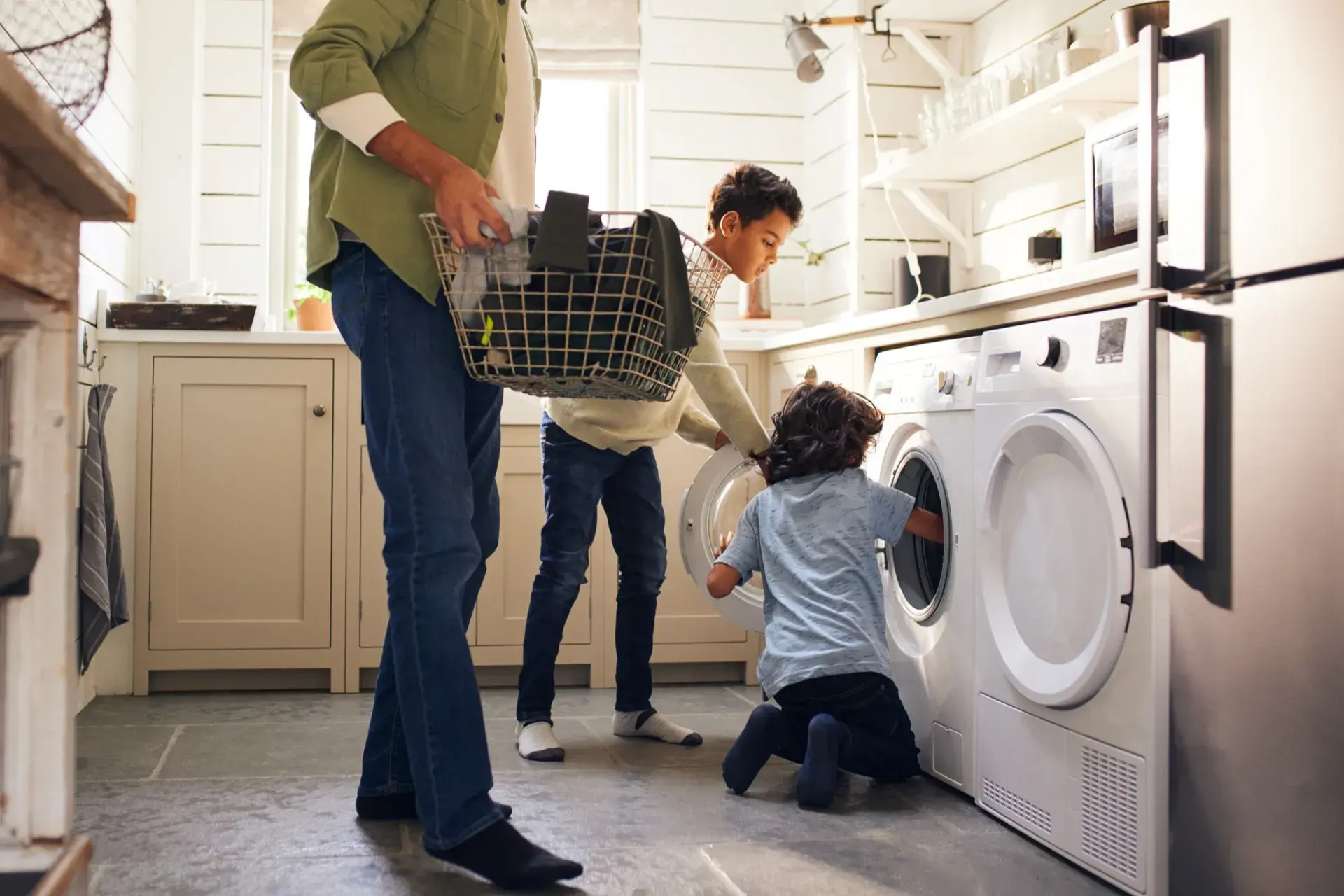 Family loading laundry into a washing machine for vacation rental laundry service